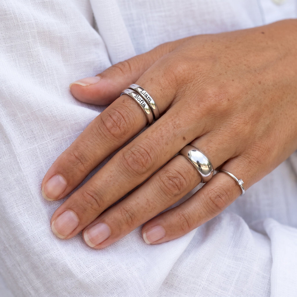 Tiny Stackable Name Ring – Silver – stacked with other rings, worn, close-up